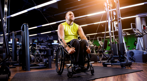 Rehabilitation training at the gym with a man in his mid 30s on a wheelchair